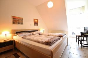 1 dormitorio con 1 cama grande y 1 mesa en Landhaus Hubertus Wohnung 8, en Cuxhaven