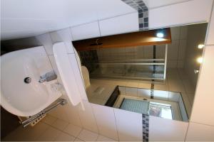 ein Bad mit einem Waschbecken und einem Spiegel in der Unterkunft Kugelbake in Cuxhaven