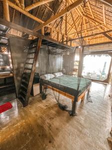 a room with a bed and a ladder in it at shakabrah beach club cottage in General Luna