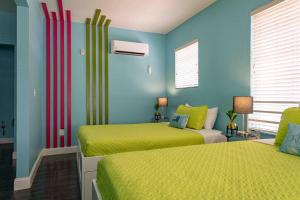 2 łóżka w pokoju w kolorze niebieskim i żółtym w obiekcie Beds n' Drinks w Miami Beach