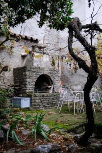 a stone building with chairs and a table in a yard at Mirador del Llac in Cellers