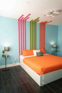 una camera da letto con un letto arancione e pareti a strisce di Beds n' Drinks a Miami Beach