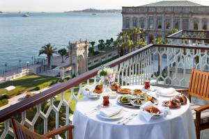 a table with food on a balcony with a view of the water at Çırağan Palace Kempinski Istanbul in Istanbul