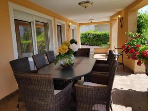 a dining room table with chairs and a vase of flowers at Residence Gordana 2 in Selce