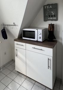 a microwave sitting on top of a cabinet in a room at FeWo Sonnenblume Achtern Diek in Zingst