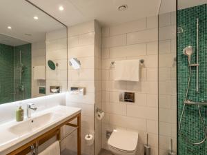 a bathroom with a sink and a toilet and a shower at Holiday Inn Munich - Leuchtenbergring, an IHG Hotel in Munich