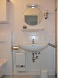 bagno bianco con lavandino e specchio di Robbenplate 19 a Cuxhaven