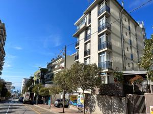 un edificio blanco alto en una calle de la ciudad en Apartaments Superiors MTB Only Couples, en Lloret de Mar