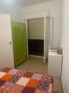 een slaapkamer met een bed, een groene deur en een raam bij Far from the Madding Crowd in Barcelona