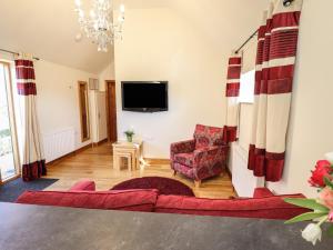 a living room with a couch and a tv at The Stables in Louth