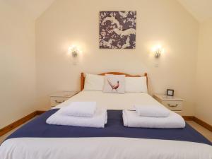 um quarto com uma cama grande e 2 almofadas em The Stables em Louth