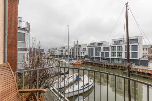 een groep boten aangemeerd in een jachthaven met gebouwen bij Wohnung 2 in Cuxhaven