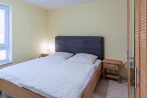 een slaapkamer met een groot bed met een blauw hoofdeinde bij Wohnung 2 in Cuxhaven