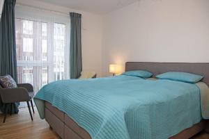 a bedroom with a bed and a large window at Haus Yachthafen 4 in Cuxhaven