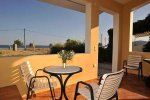 a table and chairs on a patio with a view of the ocean at Βιλλα Βεατρικη/ villa Beatrice in Pythagoreio