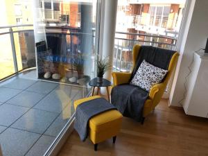 a living room with a yellow chair and a fish tank at Strand Palais 20 in Cuxhaven