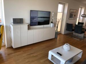 uma sala de estar com uma televisão de ecrã plano num armário branco em Strand Palais 20 em Cuxhaven