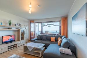 a living room with a couch and a tv at Am Sahlenburger Strand Wohnung 8 in Cuxhaven