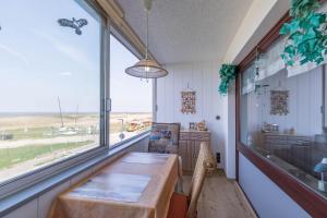 a dining room with a table and a large window at Am Sahlenburger Strand Wohnung 8 in Cuxhaven
