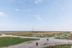 eine leere Straße mit dem Ozean im Hintergrund in der Unterkunft Am Sahlenburger Strand Wohnung 8 in Cuxhaven