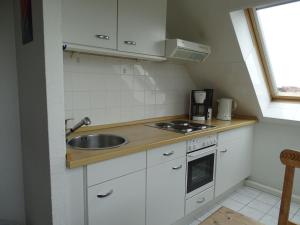 庫克斯港的住宿－Am Seedeich 7_ Wohnung 16，一间带水槽和炉灶的小厨房