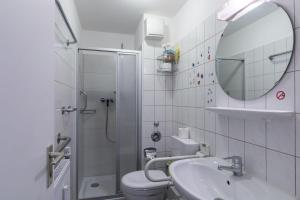 La salle de bains est pourvue de toilettes, d'un lavabo et d'un miroir. dans l'établissement Elbstrom Wohnung 8, à Cuxhaven