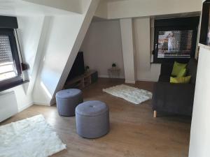 a living room with two stools and a couch and a table at Le Green Duplex moderne en hypercentre in Sarreguemines