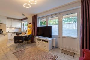 a living room with a television and a table and a kitchen at Residenz Meeresbrandung, Whg 39 in Duhnen