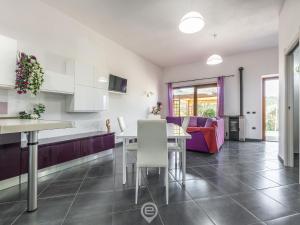 een keuken en een woonkamer met een tafel en een bank bij Floris Modern House in Gonnesa