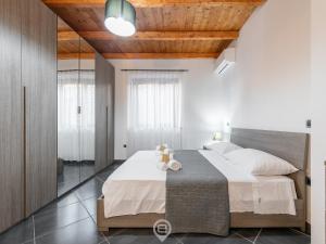 ein Schlafzimmer mit einem großen Bett und einer Holzdecke in der Unterkunft Floris Modern House in Gonnesa
