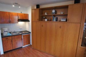 eine Küche mit Holzschränken und einem Waschbecken in der Unterkunft Haus Elbe 1 Wohnung 18 in Cuxhaven