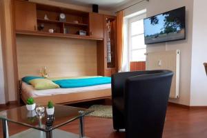 ein Schlafzimmer mit einem Bett und einem TV an der Wand in der Unterkunft Haus Elbe 1 Wohnung 18 in Cuxhaven