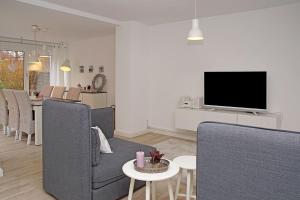 a living room with chairs and a flat screen tv at Strandlaeufer in Cuxhaven