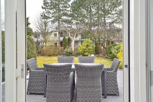 a table with wicker chairs on a porch at Strandlaeufer in Cuxhaven