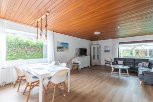 sala de estar con mesa blanca y sillas en Haus Cux, App 7 en Duhnen