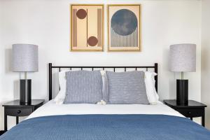 a bedroom with a blue bed with two lamps at Central Sq 2BR nr Central Sq T stop BOS-570 in Cambridge