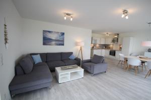 a living room with a couch and a table at Quartier Hohe Geest _ Wohnung Meer in Cuxhaven