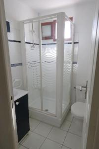 bagno bianco con doccia e servizi igienici di Un petit coin de paradis en bord de mer a Vias