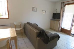 a living room with a couch and a table at Un petit coin de paradis en bord de mer in Vias