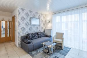 uma sala de estar com um sofá e uma cadeira em Haus Seewind Wohnung 2 em Cuxhaven