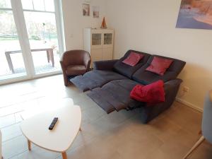 ein Wohnzimmer mit einem Sofa und einem Tisch in der Unterkunft Ferienwohnung Meeresbrise in Norden