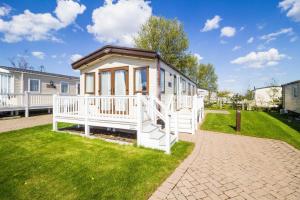 a tiny house with a porch on a lawn at Brilliant Caravan For Hire At Caister Haven Holiday Park In Norfolk Ref 30011h in Great Yarmouth