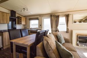 uma sala de jantar e cozinha numa caravana com uma mesa e cadeiras em Brilliant Caravan For Hire At Caister Haven Holiday Park In Norfolk Ref 30011h em Great Yarmouth
