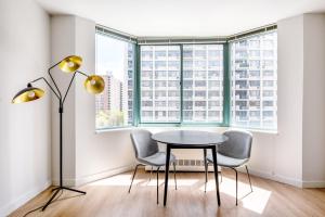 einen Tisch und zwei Stühle in einem Zimmer mit Fenster in der Unterkunft UWS 2BR w Doorman Gym Parking nr Central Park NYC-596 in New York