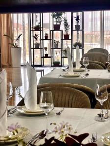 a dining room with tables with white tablecloths and glasses at Mir Luxe Plaza in Tashkent