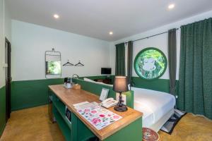 Blu Monkey Pooltara Krabi Hotel & Villas Pet Friendly في Tha Lane Bay: غرفة نوم مع سرير ومكتب مع هاتف