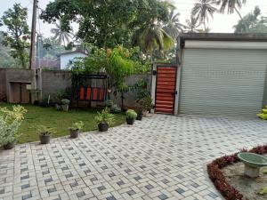 a garage with a red door in a yard at Nilwala Gate wetland Stay in Matara