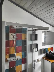 a bathroom with a shower and a colorful tile wall at La Casita: Studio cosy indépendant de 25 m² in Les Sables-d'Olonne