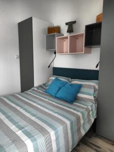 - une chambre avec un lit doté d'un oreiller bleu dans l'établissement La Casita: Studio cosy indépendant de 25 m², à Les Sables-dʼOlonne