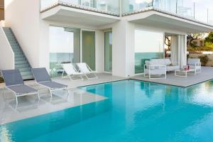 a swimming pool with chairs and a house at Bedda Matri in Noto